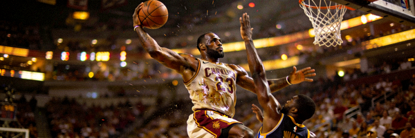 NBA球星勒布朗·詹姆斯在比赛中突破上篮，肌肉线条分明